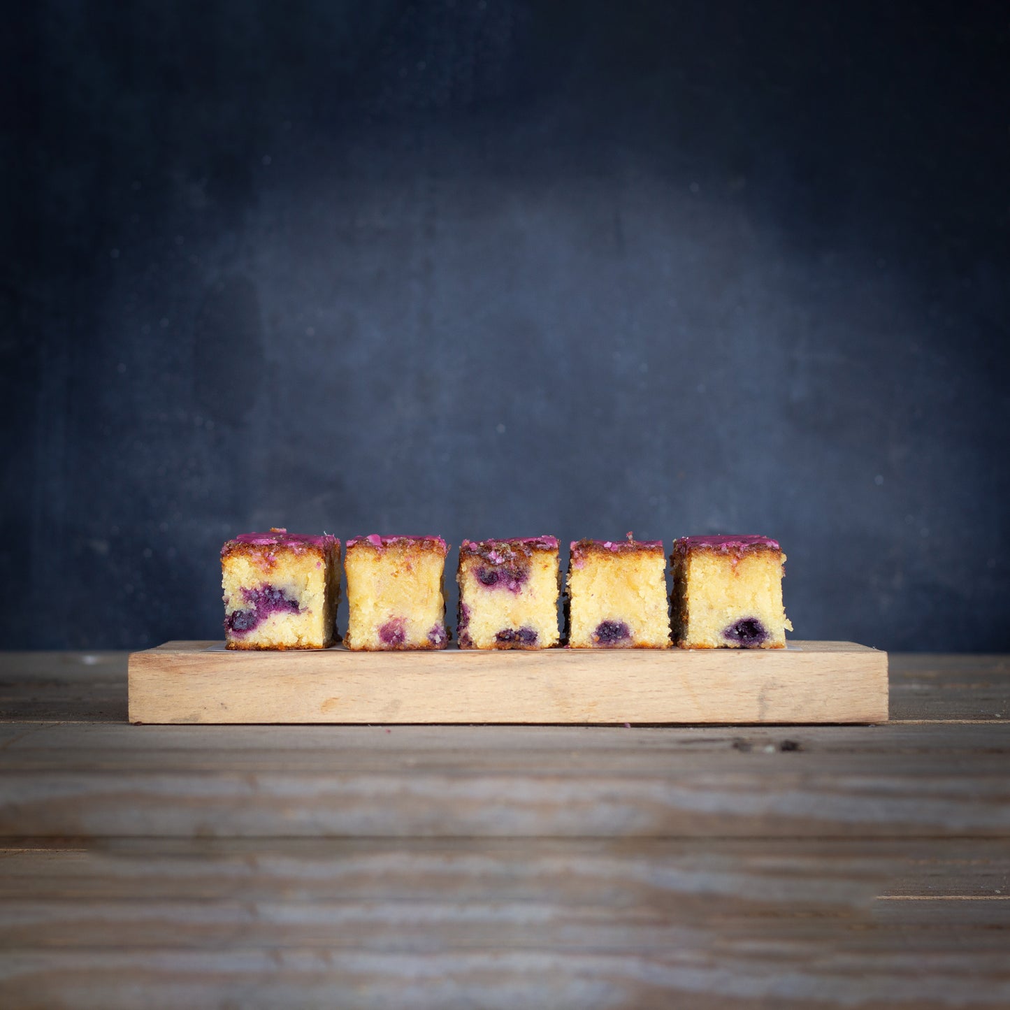 Six cake slices on a wooden board with a dark background