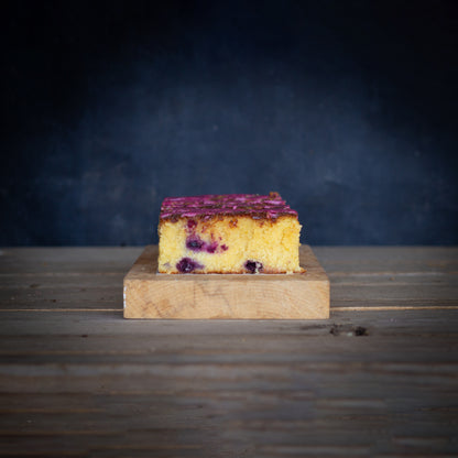 Slice of cake on a wooden board with a dark background